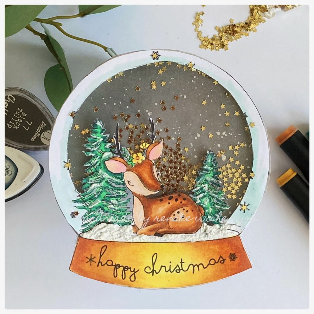 My finished Christmas shaped snow-globe shaker card. The card is in the shape of a snow-globe. With a deer and trees and shaking the golden stars.