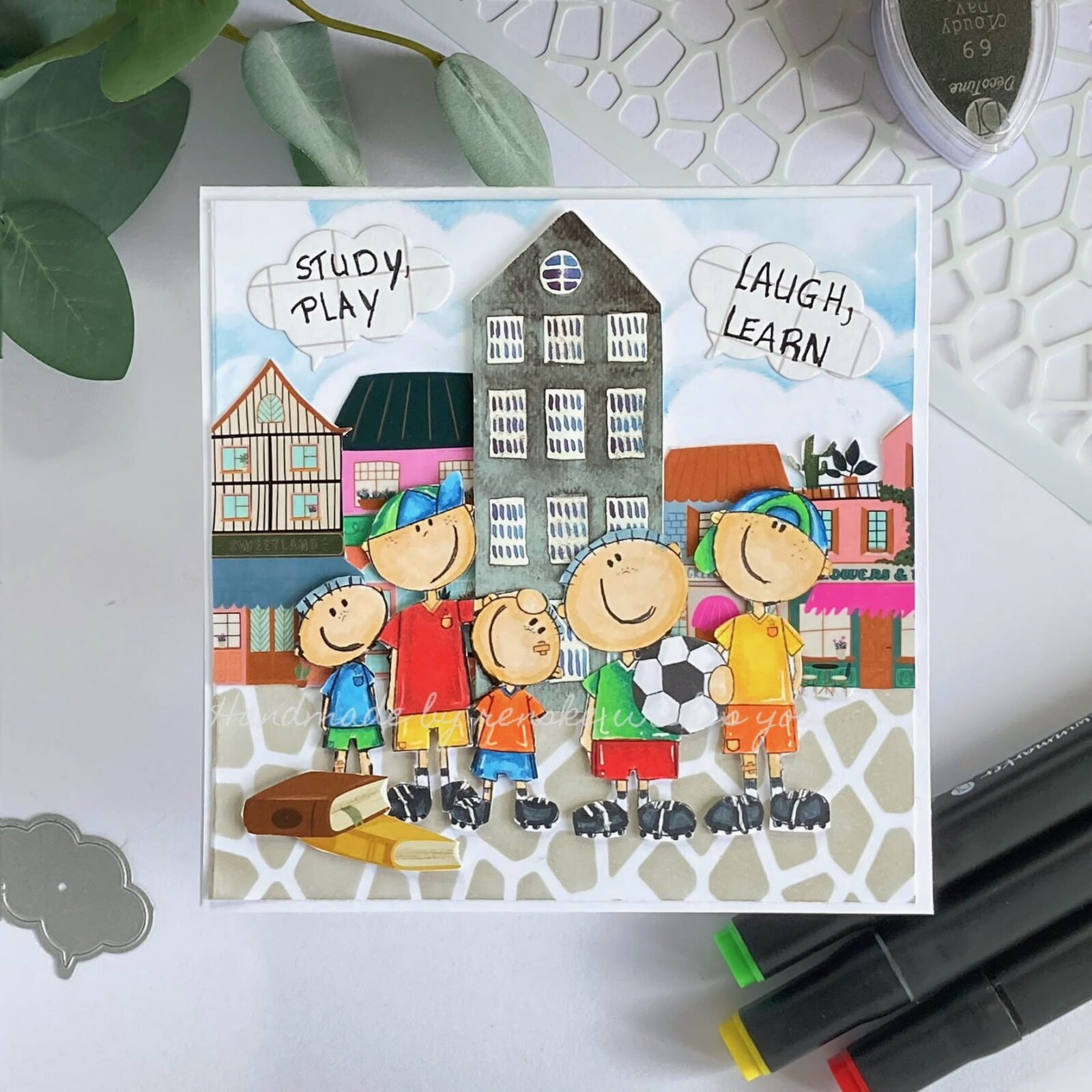 Handmade Back to School Card: Five boys in colorful T-shirts and shorts, holding a soccer ball, against a backdrop of a stone path and cloudy sky with school building stickers.