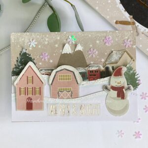Featured image of a beautifully crafted DIY Christmas card with festive decorations and a heartfelt message. It's a Christmas village with snow.