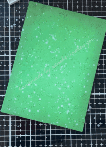 Inked and die-cut background with metallic paint splatters.