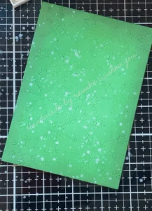 Inked and die-cut background with metallic paint splatters.