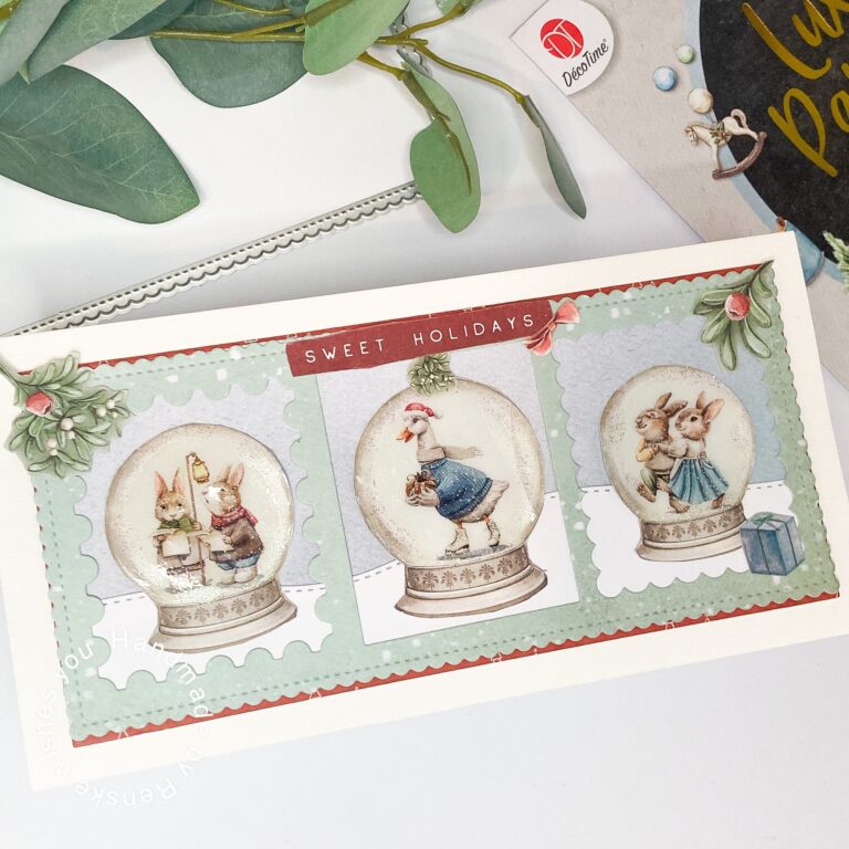 A DIY Snow Globe card for Christmas featuring three snow globes with festive scenes, surrounded by seasonal decorations like mistletoe, berries, and a red banner with the phrase 'Sweet Holidays