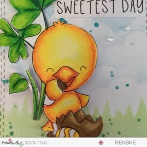 Close-up of the beautifully colored 'Chocolate Time Chick' digital stamp against a scenic background of grass and clouds. This handmade Spring Chick Card showcases vibrant colors, intricate details, and a charming outdoor setting. Crafted with the Polkadoodles digital stamp, this card radiates joy and creativity, perfect for celebrating the spring season