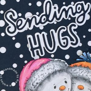 Close-up view of the sentiment 'Sending Hugs' on a handmade winter-themed card, adding warmth and heartfelt wishes to the charming snowman scene."