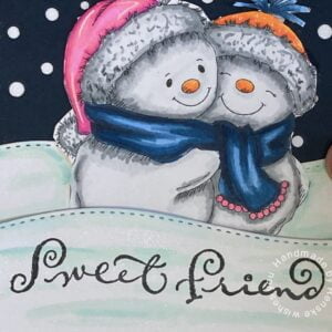 Close-up view of heartwarming snowmen sharing a hug on snowy hills, accompanied by the sentiment 'Sweet Friend' on a handmade winter-themed card.