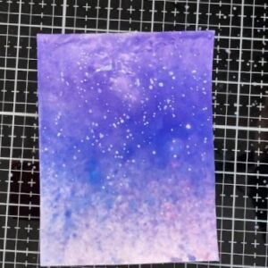 Picture of the finished background made with acrilyc paint spray and metallic paint splatters.
