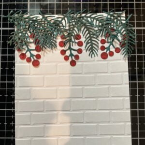 A picture of placing the needles and berries on the stone wall background.