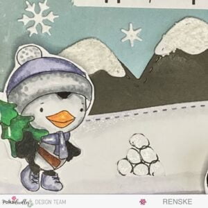 Close-up of Wanda, a hand-coloured digital stamp, holding a Christmas tree, part of a winter-themed slimline slider card featuring Polkadoodles' adorable penguins.