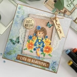Overhead view of the complete handmade flower girl card displayed on a tilted surface. The card features a Polaroid frame with a flower girl surrounded by colorful flowers.