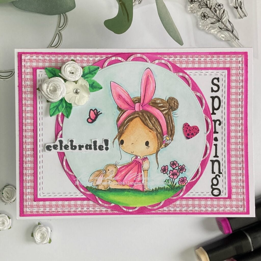 Top-down view of completed handmade spring card: This image shows the entire handmade spring card from a top-down perspective, with the card positioned upright. The card features the adorable Bunny Hairband digital stamp, coloured with vibrant spring hues. Layers of patterned paper and decorative embellishments add depth and dimension to the design, creating a visually appealing card that captures the essence of springtime.