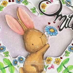 Close up picture coloured rabbit and flowers digital stamp Say it with Flowers A close-up photo focusing on the coloured rabbit from the "Say it with Flowers" digital stamp, emphasizing the intricate details of the image. The rabbit is delicately coloured with shades of brown, grey, and peach, holding a vibrant flower in its paws.