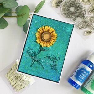 Mixed media sunflower card Studiolight (2) Top-down view of a handmade mixed media flower card. The card's vibrant colours and textured background are highlighted in the image.