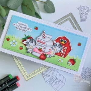 Other angle Slimline birthday cow card streamside studios An angled overhead photo of the Slimline Strawberry Cow birthday card. The card is positioned diagonally, showcasing the scene from a dynamic perspective.