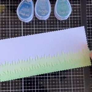 Positioning-the-grass-stencil-to-create-the-sky Placing the grass stencil before inking the sky