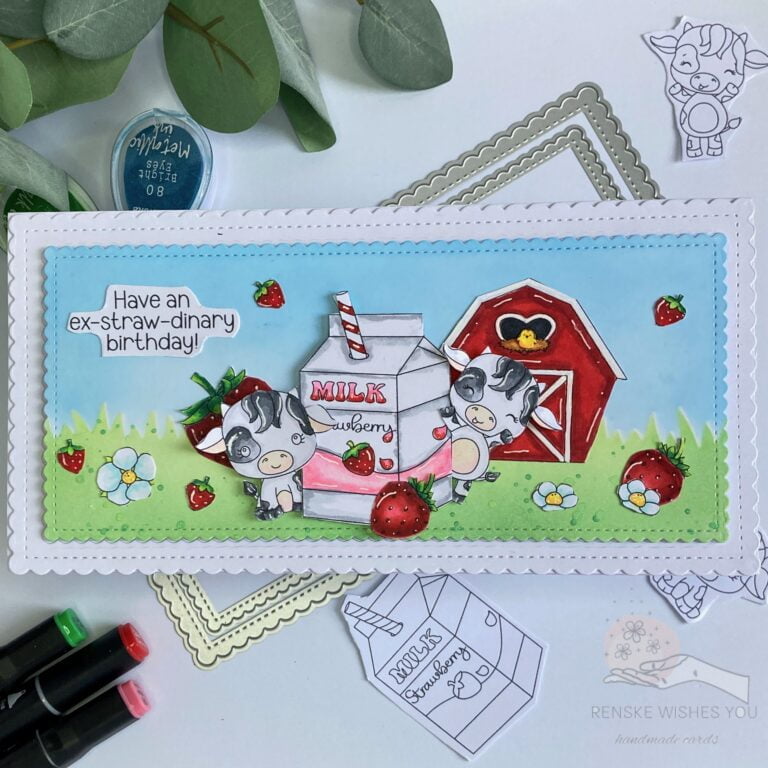 An overhead photo showing the entire Slimline Strawberry Cow birthday card. The card features a charming scene with cows, strawberries, a barn, and a milk carton against a backdrop of grass and sky.