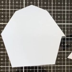 The blank barn shaped card base Blank card base cut into the shape of a barn. The card base has been cut and shaped to resemble a barn, with the outline clearly defined and ready for further embellishment.
