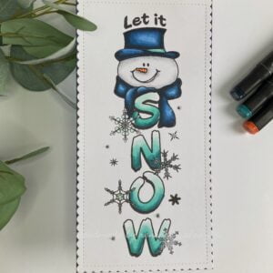 Vertical let it snow D.R.S. Deisgns 1 op-down view of the completed winter card featuring a charming snowman design, captured from directly above. The card exhibits the snowman stamp along with other decorative elements and intricate detailing.