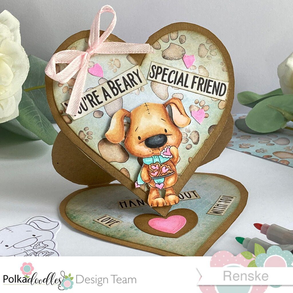 Front view of the handmade easel card, slightly tilted to showcase the layered design. The card features a dog with heart-shaped cookies, accented with patterned paper and a pink bow, emphasizing the unique and heartfelt elements of this handmade card. Handmade easel card tutorial.