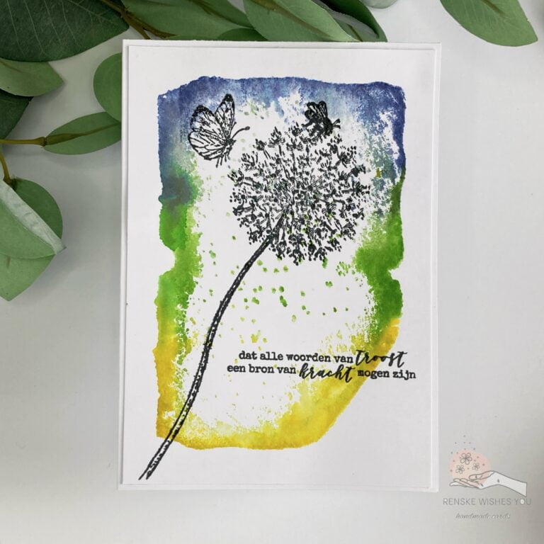 A top-down view of the complete handmade sympathy card, featuring a distressed background in shades of blue, green, and yellow, adorned with stamped dandelion and butterfly motifs, and sentiment