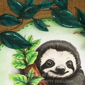 A close-up photo of the leaves surrounding the circular window on the handmade sloth card. The leaves are meticulously arranged around the circular frame, adding depth and dimension to the card design.