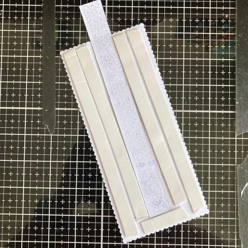 How to put the foam tape and the strip Photo showing the back of the hot air balloon slider card's background panel with foam tape applied. The image demonstrates how the slider mechanism fits between the foam tape