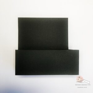 Folded base card in a box Folded black card base for a Halloween card in a box, showing the structure after folding but before decoration.