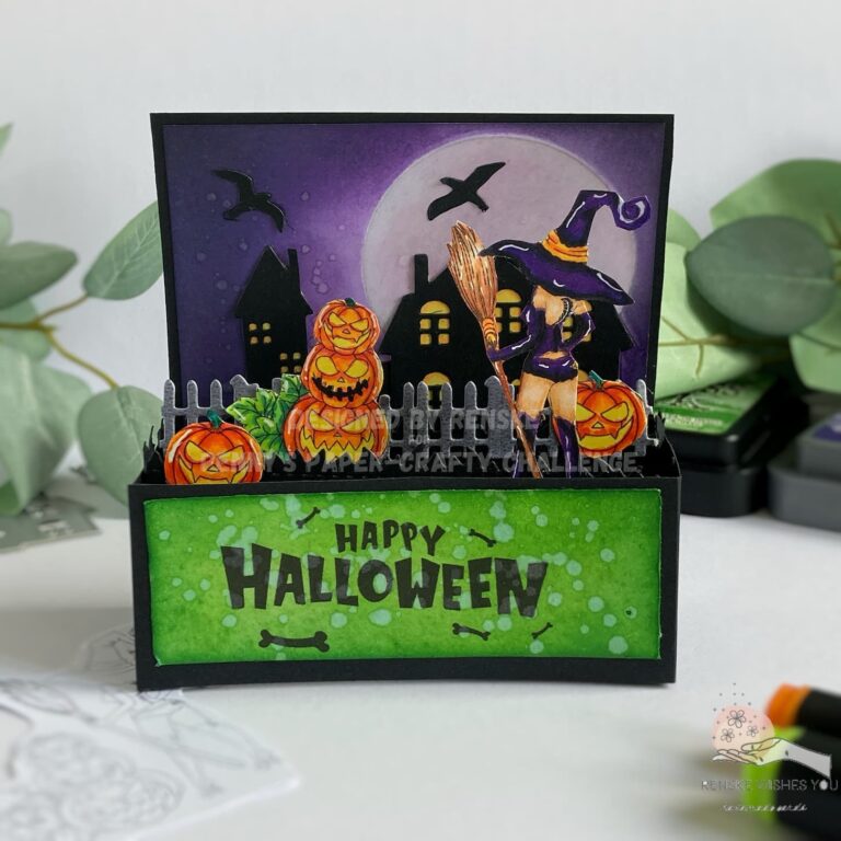 Front view of a completed Halloween card in a box featuring a spooky scene with a witch and pumpkins