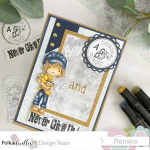 Back to school student school little dude digital stamp The handmade back-to-school card viewed from a slightly angled top-down perspective. The card showcases the same elements as in the previous photo but at a diagonal angle. The kraft base is visible with its blue and pattern paper layers. The focus is on the rectangular kraft frame containing the chalkboard paper. The circular blue embellishment with the sentiment 'Wishing you a great day' is prominent, and the gold 'and' letters are positioned on the chalkboard. The 'Never Give Up' sentiment is visible below the frame, with the colored digital stamp image placed above it. The blue banner with gold rhinestones is located in the top left corner.