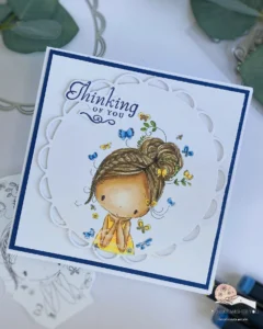 Clean and Simple Thinking of you card All Dressed Up Stamps 1 Top-down view of a Handmade Thinking of You card at an angle, showing the card’s clean and simple design. The image of the girl and the scalloped circle die-cut are clearly visible, with the blue card base and white background layer providing a contrasting backdrop