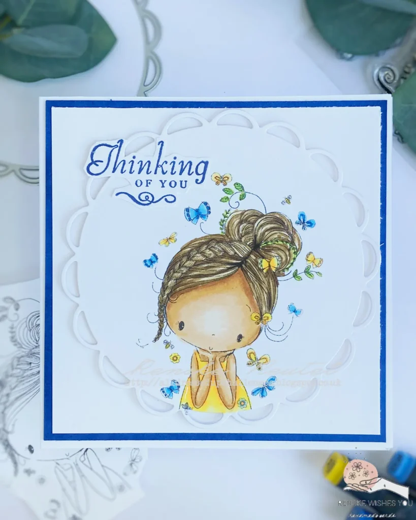 "Top-down view of a Handmade Thinking of You card featuring a clean and simple design. The card showcases a die-cut image of a girl lost in thought, framed by a scalloped circle die. The card base is blue with a white background layer, and the sentiment 'Thinking of You' is prominently displayed