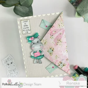 Hippo Helga envelope flap card Polkadoodles 1 Angled view of the closed envelope flap card. The card displays a digital stamp of Helga Hippo from Polkadoodles, set against a beige patterned paper background with delicate floral and stripe patterns. The hippo is positioned in the center, with additional details such as a heart embellishment, a stamped 'Postcard' design, and layered paper elements that create depth and texture. The card's flap is prominent, adding dimension to the design."