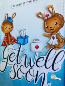 Picture to show the dimension of the digital stamps on this get well soon card Side view of a handmade get well soon card, showing the dimensional arrangement with raised elements like the digital stamps of bunnies, a large 'Get Well Soon' sentiment, and embellishments like a tissue box and a doctor's bag, adding depth and texture to the design.