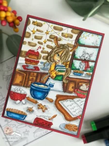 Rory Bake time colouring page Christmas Card 1 Angled view of a handmade Christmas card featuring the 'Rory Bake Time' digital stamp from Colour of Love. The card is positioned at an angle to show depth, highlighting the details of the coloured scene and the festive decorations around it, ideal for those who want to colour their own Christmas card