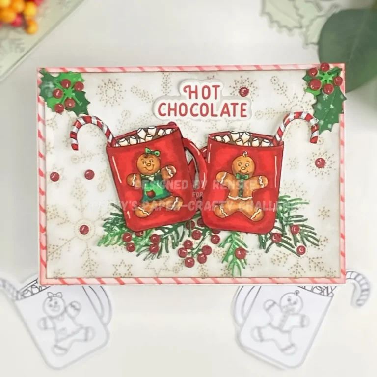 An overhead shot of the complete Hot Chocolate Christmas Card, featuring two gingerbread mugs with, surrounded by holly and berries, and set against a festive background with ice flower and red and white striped background.