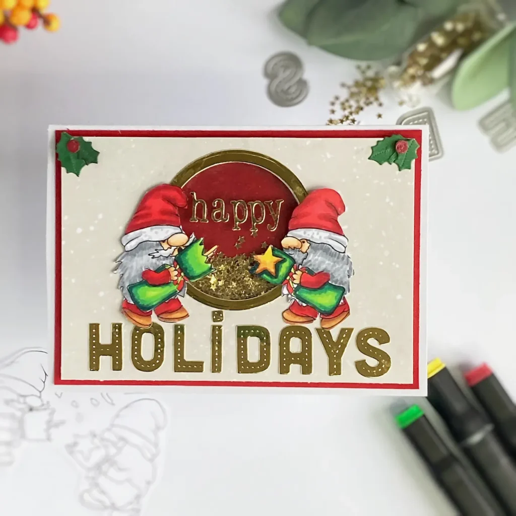 Top-down view of a Christmas shaker card, featuring a festive design with two gnomes pulling a cracker, both wearing holiday hats and positioned face-to-face in front of shaker window. The card includes shiny golden and patterned papers, with red, green, and white holiday-themed accents, making it a festive card for friends and family.