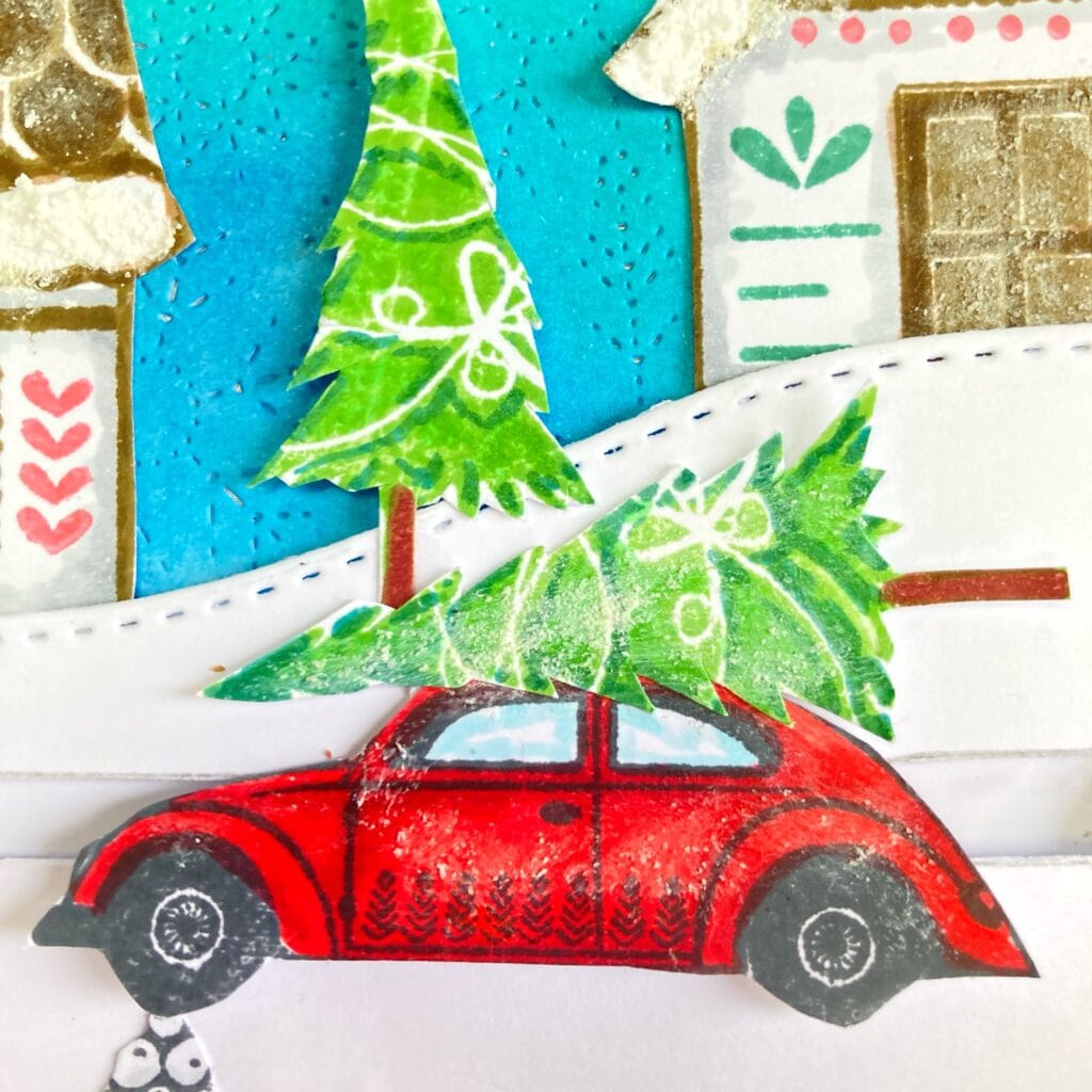 Close up picture of the car stamp Close-up of the car from the Christmas slider card, carrying a green Christmas tree and detailed with red and snowy elements for a festive touch.