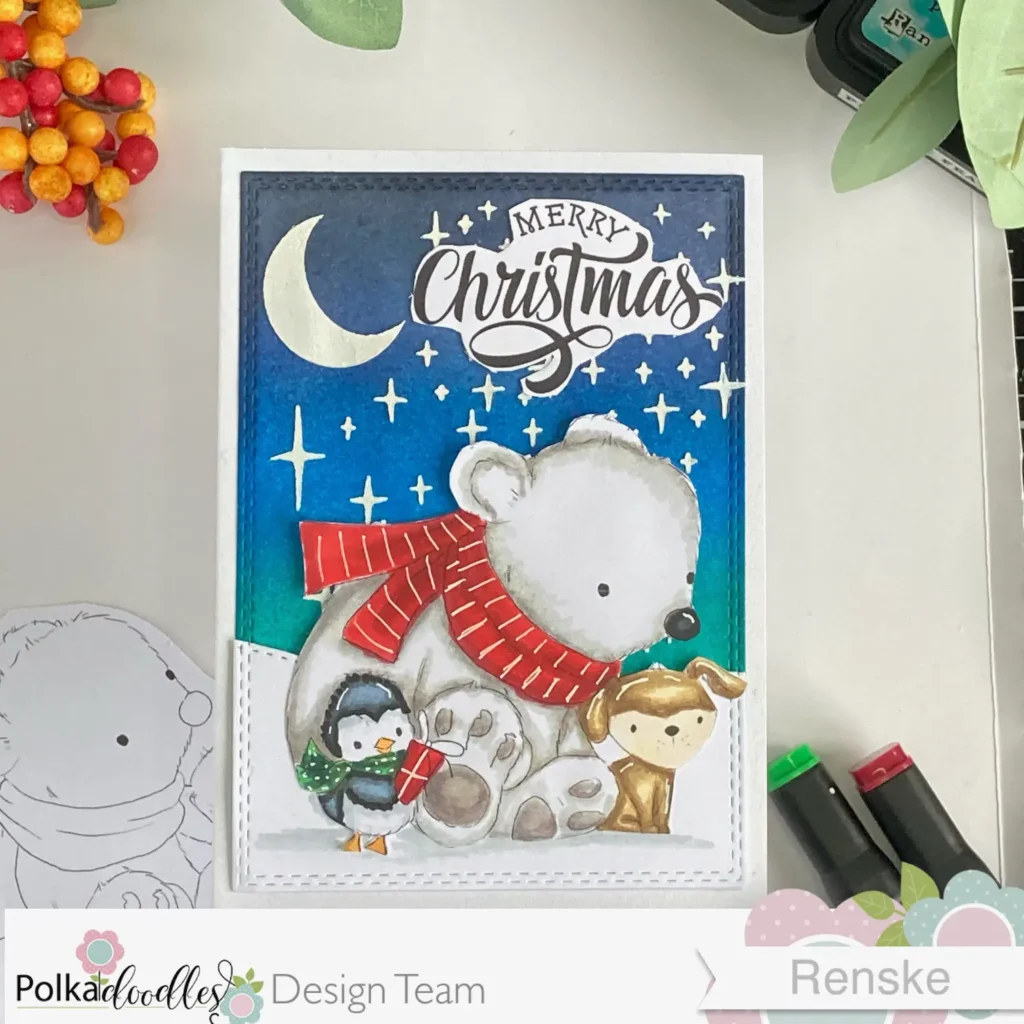 Overhead view of a handmade Cute Animal Christmas Card, featuring the 'Cute Snowfriends' digital stamp. The card shows a festive winter scene with a polar bear, dog, and penguin, all wearing cozy winter scarves. A softly blended evening sky and snowy hill create a warm holiday backdrop with stars and a moon visible in the background.