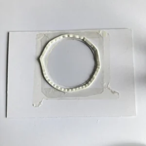 Close-up of foam tape placed around the edges of the shaker window on the Christmas card. The foam tape creates a frame to contain the shaker elements, ensuring they move freely within the window when the card is shaken.