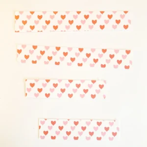 4 patterned paper strips Four strips of heart-patterned paper, ready to decorate the red box of the valentine treat box.