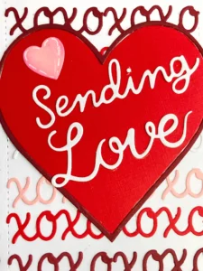 Close up sentiment Sending Love (1) A close-up of the heart element on the DIY Valentine card design, showcasing the “Sending Love” text, stitched details, and subtle Picked Raspberry Distress Ink shading for depth