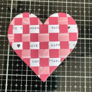 Paper Weaving Heart A close-up of the paper-woven heart in the DIY Valentine's Day card, showing the intricate weaving technique and colour contrast.