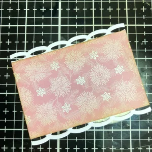 Picture of the pink patterned paper with weave edges Pink patterned paper with wave edges, ready to be layered onto the tea bag-shaped card for a whimsical and elegant look.