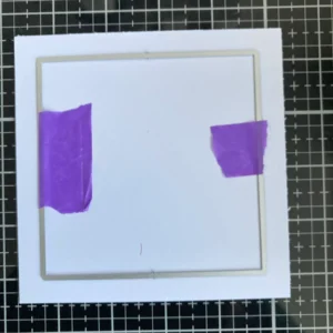Square die making the frame Process of die-cutting the frame for the cactus thank you card. A large square die is positioned to cut an even frame from white cardstock.