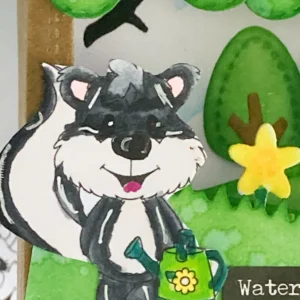 Close upof the coloured skunk digital stamp Close-up of the coloured digital stamp used in this shadow box card tutorial. The skunk holding a watering can is shaded with soft blending for a detailed look.