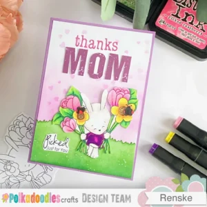 Handmade Mother's day card Bunny bunch flowers Polkadoodles (3) A top-down angled view of the handmade Mother's Day card, showcasing the layered elements. The bunny illustration is cut out and placed with foam tape for dimension. The heart stencil pattern in the background softly fades upwards, while the grass border blends from deep to light green for a natural effect.