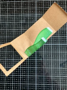 How to place the grass hills in the shadow box Step-by-step image from the shadow box card tutorial showing how to attach the hills inside the box. These layers create depth and dimension.