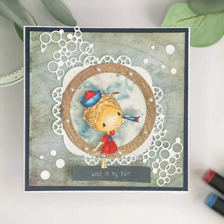 Top-down view of a finished nautical greeting card with a layered design featuring a digitally coloured Little Sailor stamp, soft blue inky background, die-cut elements, and a vellum boat window on a clean white card base.