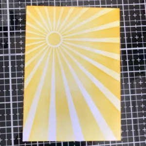 Background sunbeams with distress ink Detail photo of the sunray background created for the handmade summer card. The rays are ink-blended with Distress Inks in various shades of yellow, radiating from the top left corner. The blending creates a warm, summery glow.