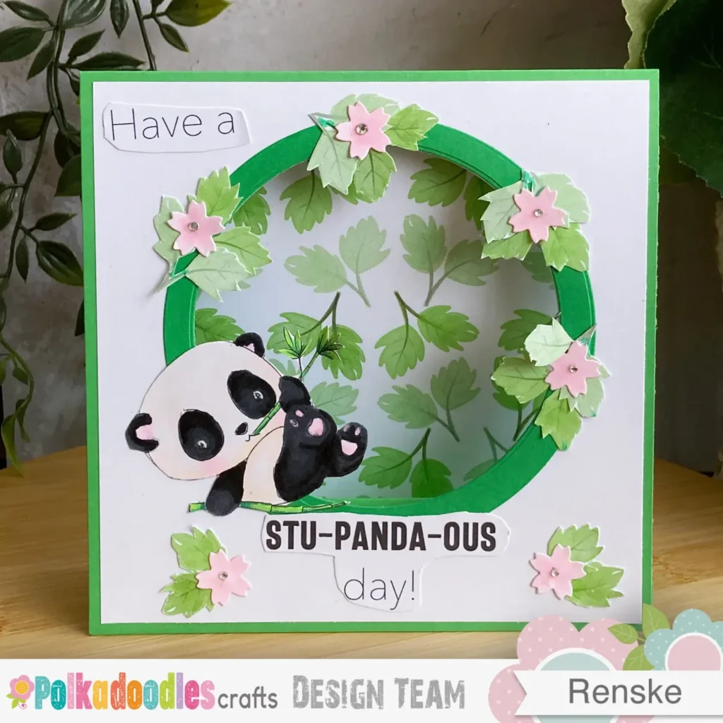 Front-facing view of the completed tent fold card standing upright. The panda image is framed in a green circle, surrounded by hand-cut leaves and pink flowers. The sentiment is positioned neatly beneath the focal point, showing the clean, balanced layout from this tent fold card tutorial.