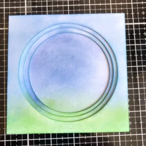 Layered tunnel card panels sembled tunnel card layers stacked together, showing the 3D structure from a side angle. Each panel is evenly spaced using foam tape, and you can see how the die-cut windows line up to frame the focal point.